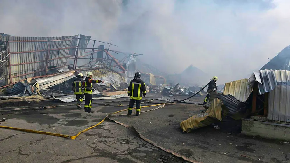 Feuerwehrleute löschen das Feuer nach einem russischen Drohnenangriff auf Lagerhäuser. Foto: Michael Shtekel/AP/dpa