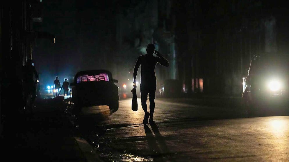 dpatopbilder - Ein Passant auf einer dunklen Straße während des Stromausfalls in Havanna. Foto: Ramon Espinosa/AP/dpa