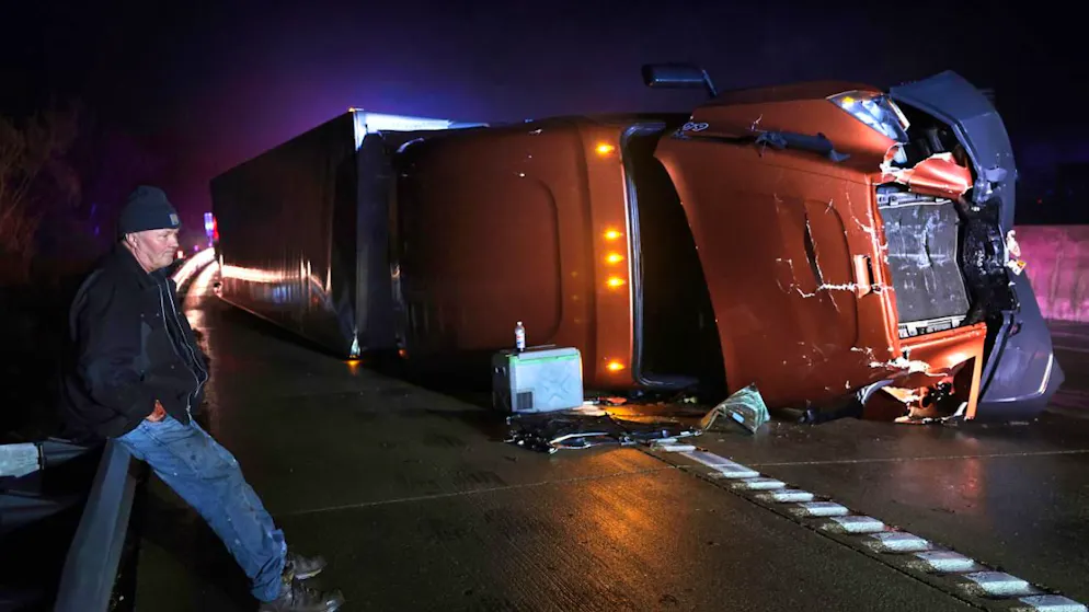Mark Nelson aus Wisconsin wartet mit seinem Sattelzug, nachdem dieser während starker Winde und eines möglichen Tornados auf der Interstate 44 in westlicher Richtung bei Villa Ridge, Missouri, umgekippt ist. Foto: Robert Cohen/St. Louis Post-Dispatch via AP/dpa - ACHTUNG: Nur zur redaktionellen Verwendung und nur mit vollständiger Nennung des vorstehenden Credits