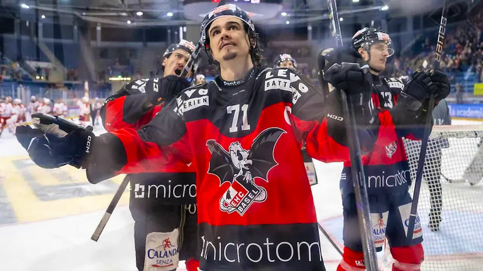 The Basel players with Brett Supinski (center) celebrate after winning the first game of the playoff final against Visp