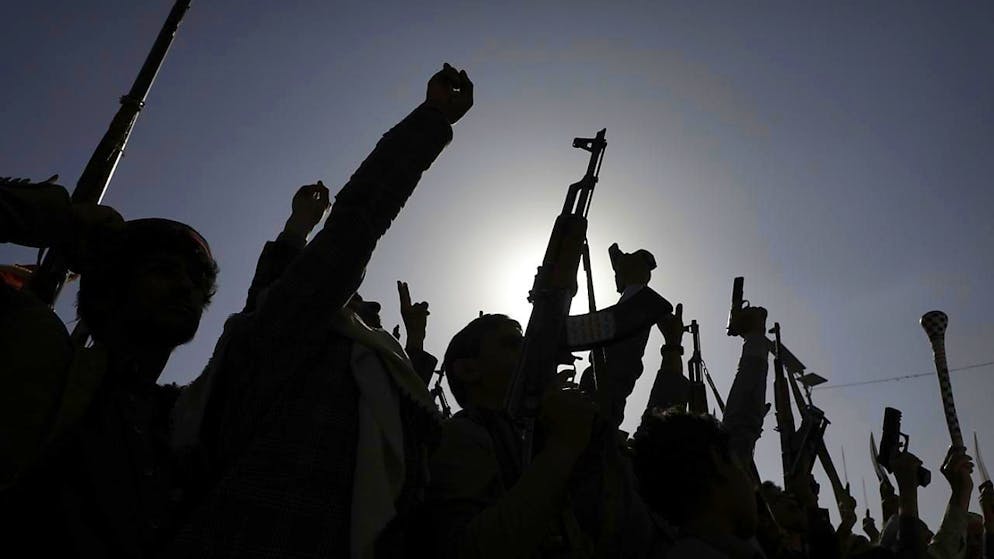 ARCHIV - Huthi-Anhänger heben während einer Kundgebung gegen die USA und Israel ihre Waffen und rufen Parolen. Foto: Osamah Abdulrahman/AP/dpa/Archivbild