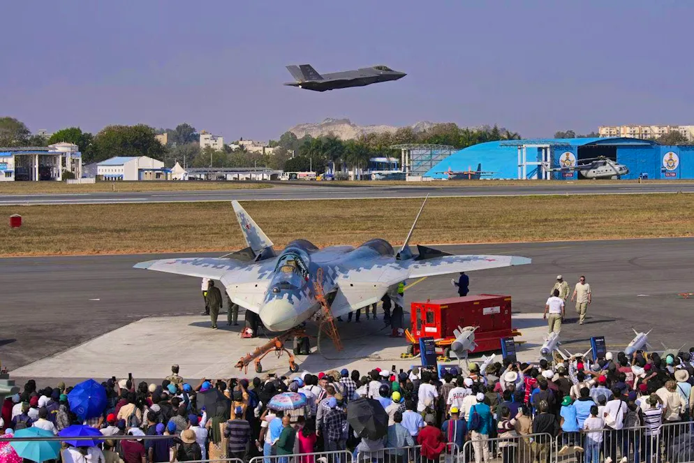 An American F-35 takes off at an air show in Bengaluru, India, on February 13, while visitors marvel at a Russian Su-57 in the foreground.