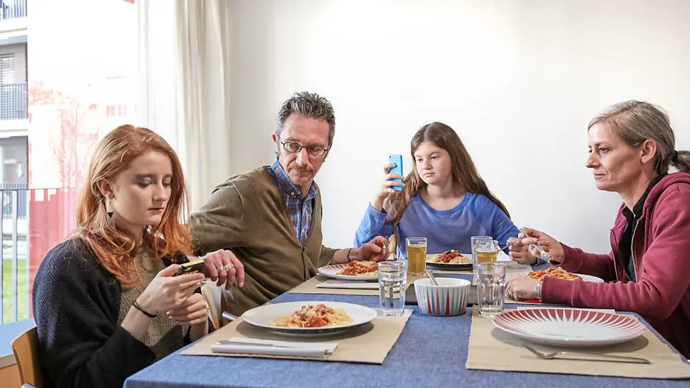 Eine Familie beim Mittagessen: der richtige Umgang mit sozialen Medien beschäftigt Familien in der Schweiz zunehmend, vor allem, wenn die Kinder in der Pubertät sind. (Symbolbild)