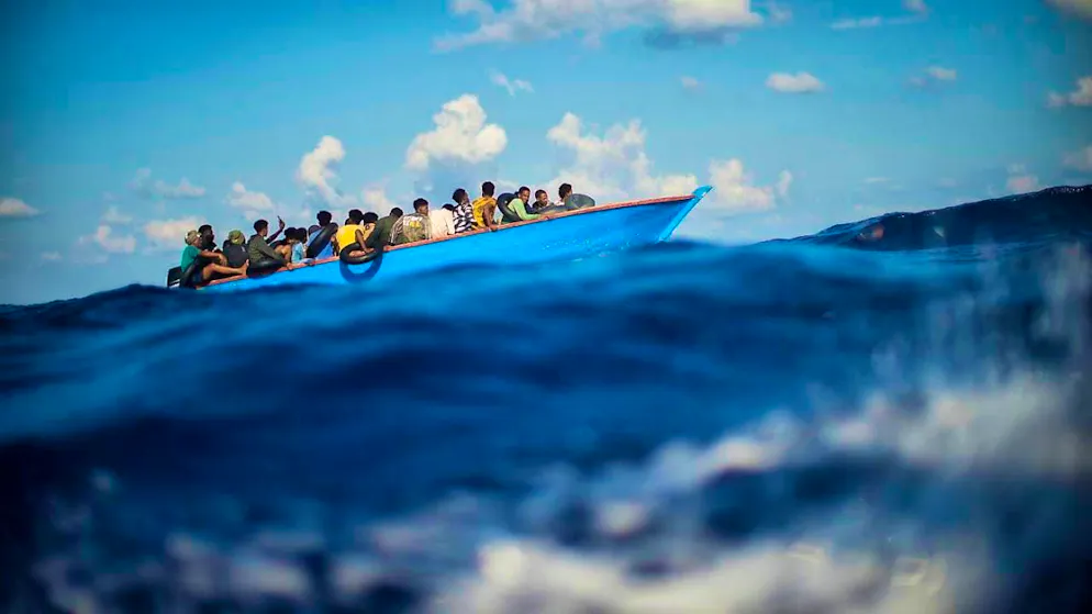 ARCHIVE - Migrants sit in a wooden boat in the Mediterranean. Photo: Francisco Seco/AP/dpa
