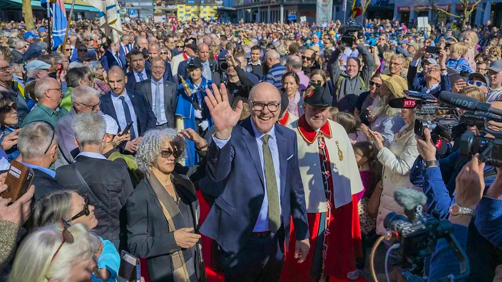 The new Federal Councillor Martin Pfister (center) and his wife Cacilda Pfister (center left) are ceremoniously welcomed by the population.