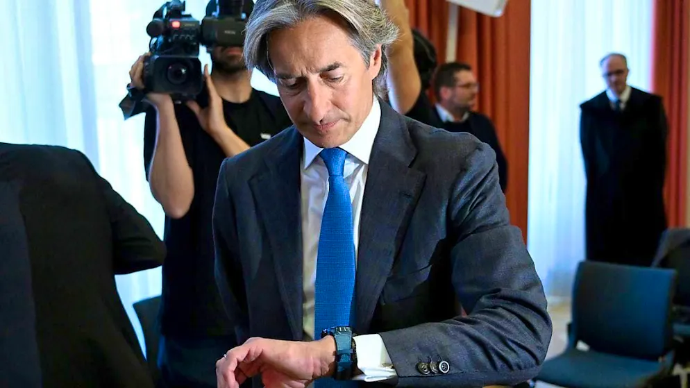 Karl Heinz Grasser, former Austrian Finance Minister, looks at his watch before the hearing begins. Grasser was convicted of bribery in the first instance. Now the Supreme Court is reviewing the case. Photo: Roland Schlager/APA/dpa