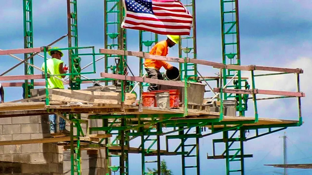 ARCHIVE - Construction workers work on scaffolding at a building site for residential and commercial units in Pennsylvania. Photo: Keith Srakocic/AP/dpa