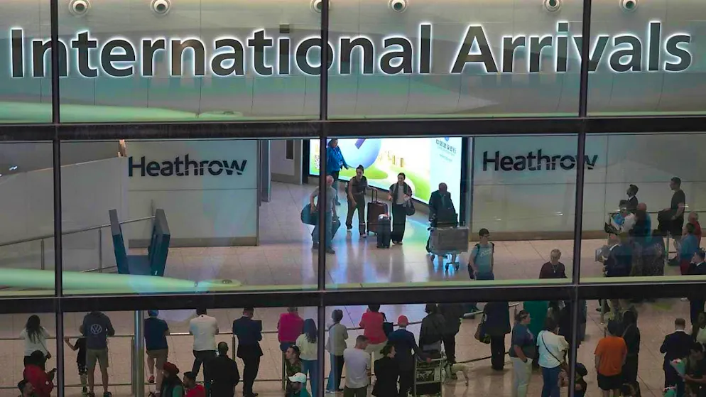 ARCHIVE - Passengers arrive at Heathrow Airport in London. Photo: Kin Cheung/AP/dpa