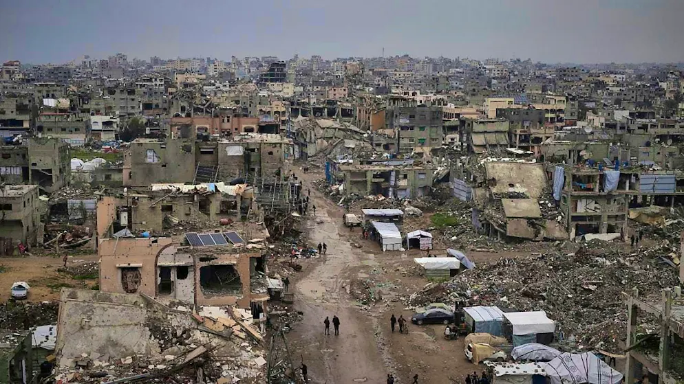 ARCHIVE - Palestinians walk through the rubble of destroyed houses and buildings in Gaza City. Photo: Jehad Alshrafi/AP/dpa