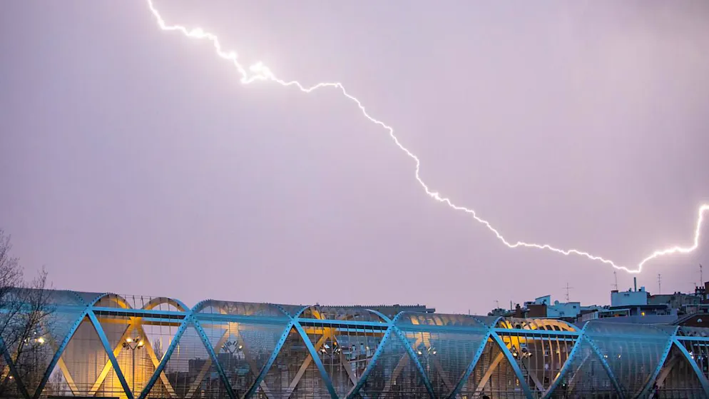 dpatopbilder - Ein Blitz entlädt sich während des Sturms «Martinho» über der Perrault-Brücke am Fluss Manzanares. Foto: David Canales/SOPA Images via ZUMA Press Wire/dpa