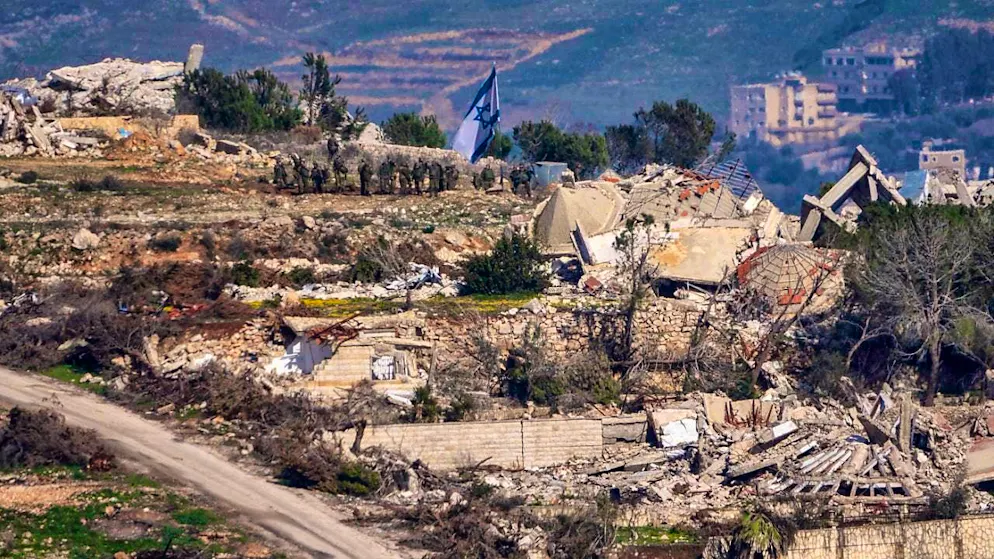 ARCHIVE - Israeli soldiers stand next to an Israeli flag in a village in southern Lebanon, taken in northern Israel. Photo: Ariel Schalit/AP/dpa