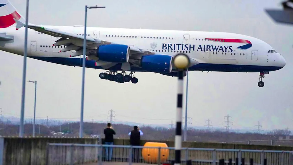People watch a British Airways plane land as authorities announce the partial resumption of flights after a fire at a nearby substation led to the closure of Europe's busiest airport. Photo: Kin Cheung/AP/dpa