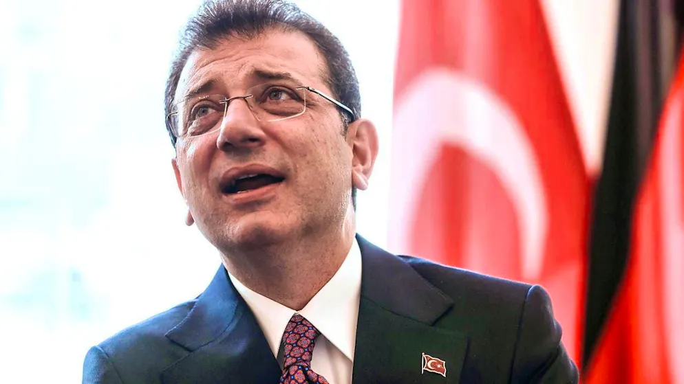 Ekrem Imamoglu, mayor of Istanbul, stands in front of a Turkish flag at a reception in the city hall.