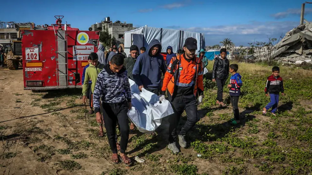 Palästinenser tragen eine Leiche, die von Mitarbeitern des Zivilschutzes unter den Trümmern eines durch einen israelischen Luftangriff zerstörten Hauses geborgen wurde. Foto: Abed Rahim Khatib/dpa
