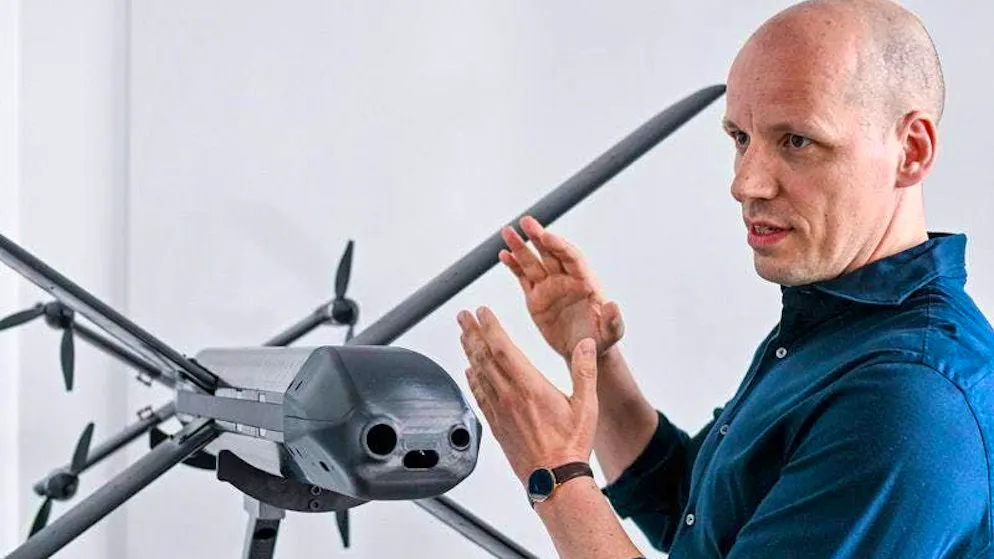 Gundbert Scherf, co-founder and co-CEO of Helsing, stands by a model of an HX-2 drone.