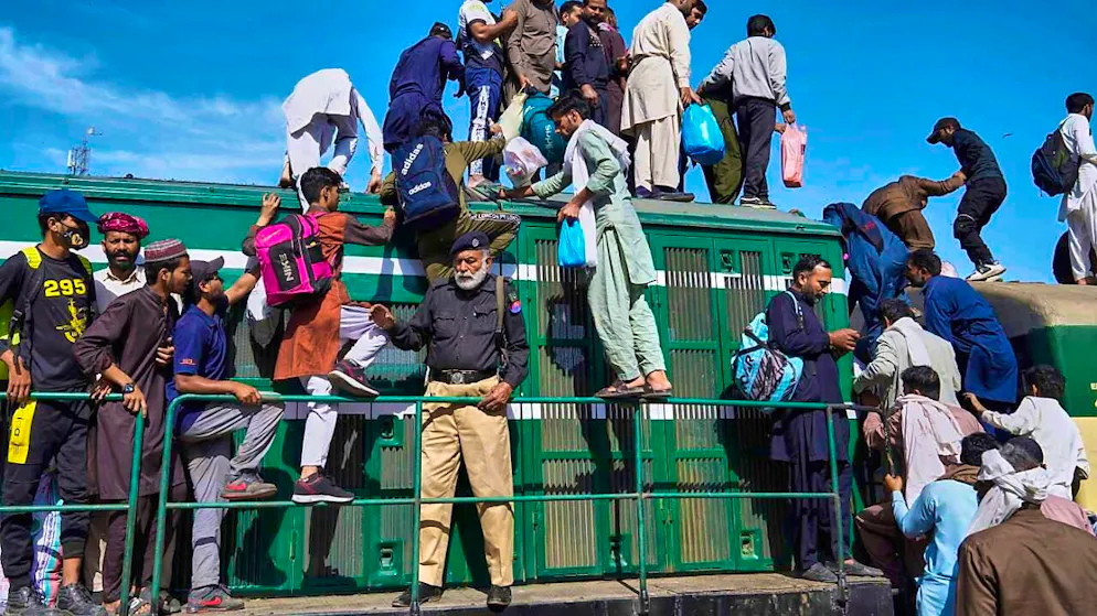 People board a crowded passenger train at a railroad station in Lahore to reach their homes to celebrate the upcoming Eid al-Fitr festival, which marks the end of the holy Islamic fasting month of Ramadan. Photo: K.M. Chaudary/AP/dpa
