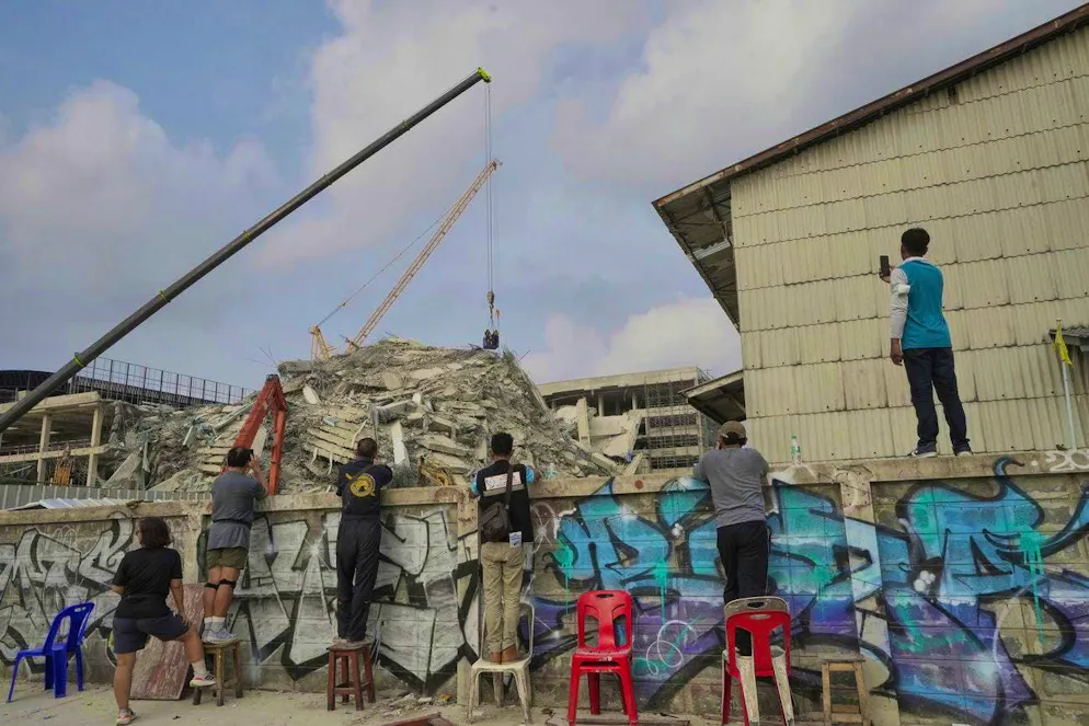 Onlookers watch rescue operations at a collapsed high-rise building in Bangkok today.