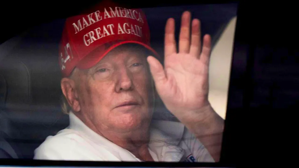 US President Donald Trump waves to his supporters from his limousine as he arrives at the Trump International Golf Club. Photo: Manuel Balce Ceneta/AP/dpa