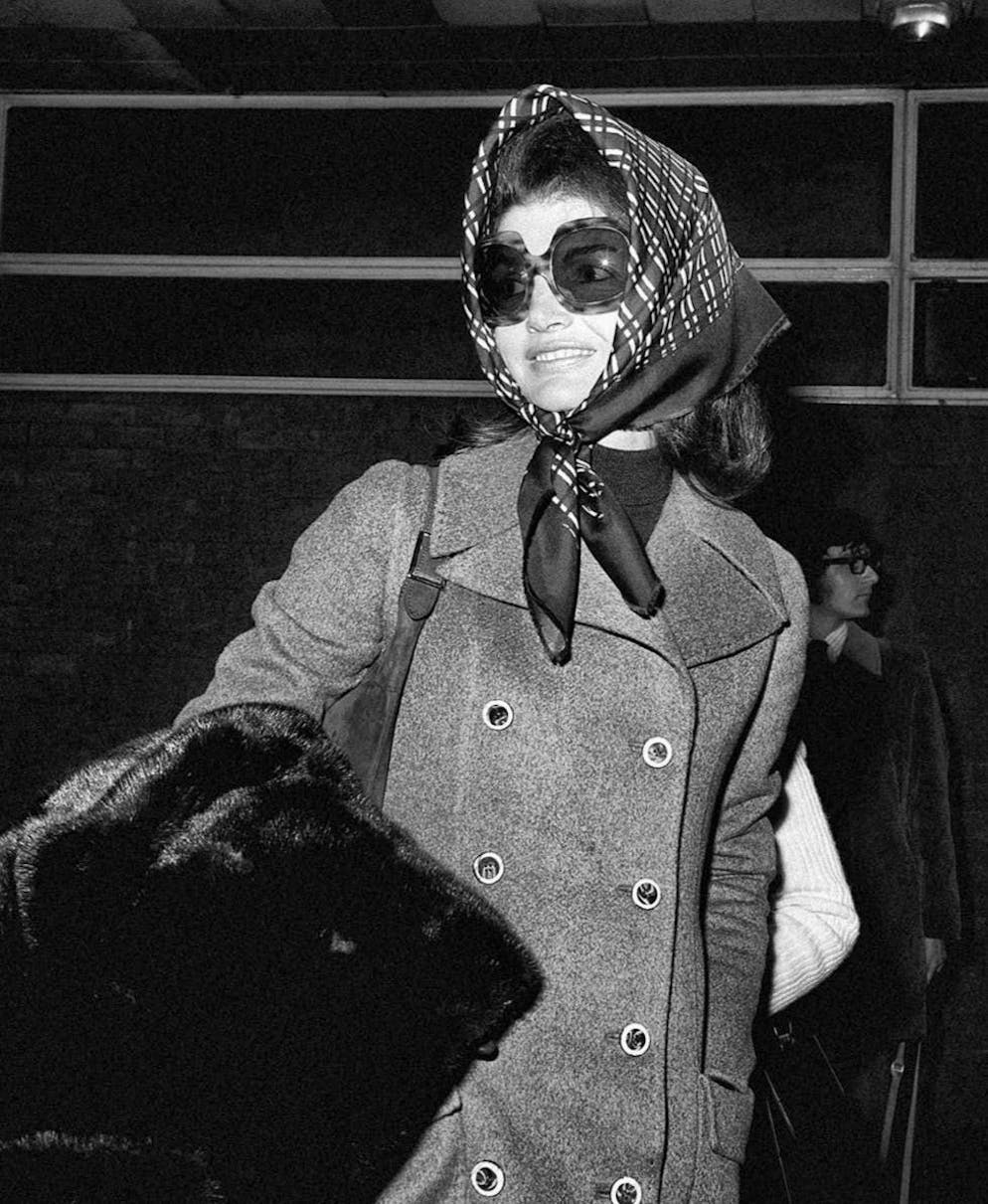 Le celebrità si ispirano all'icona di stile Jackie Kennedy. Jacqueline Kennedy, una fashionista prima del tempo, ha fatto del foulard legato in testa un elemento chiave del suo look. E il trench era il capo base del suo guardaroba.