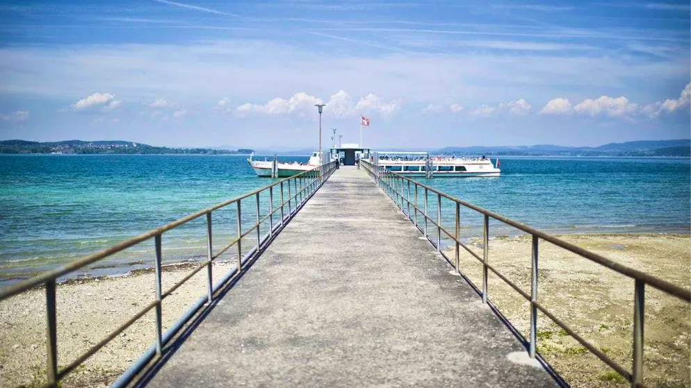 View of a jetty with a round trip ferry on Untersee in Mannenbach, Thurgau.