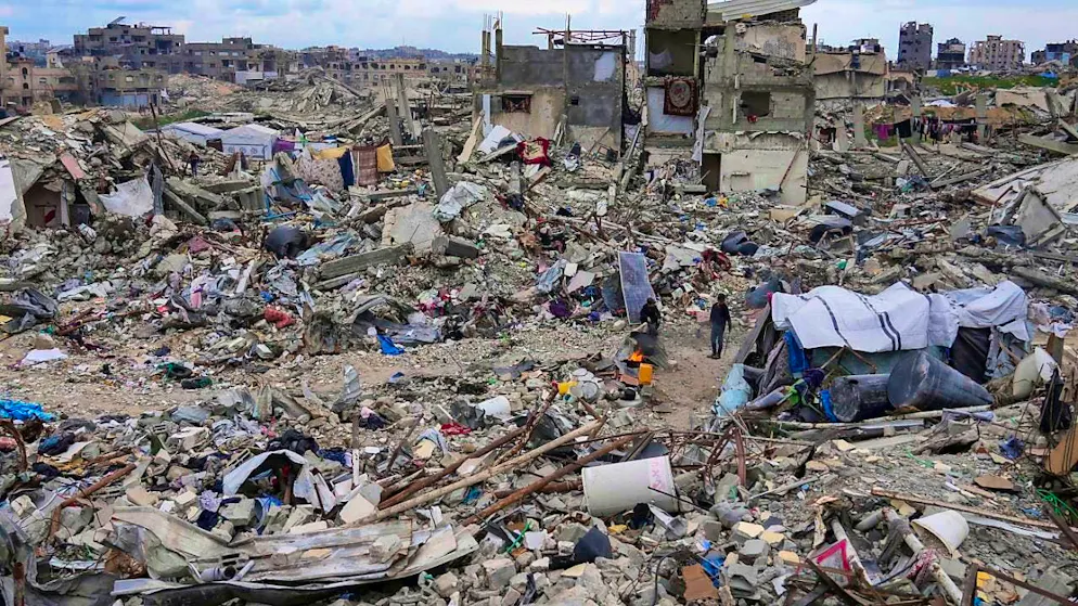 ARCHIVE - People walk amid the rubble of houses destroyed by the Israeli army's air and ground offensive against Hamas, in the northern Gaza Strip. Photo: Abdel Kareem Hana/AP/dpa