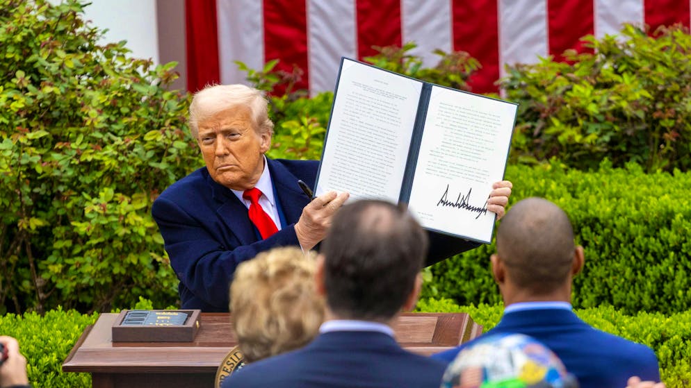 US President Donald Trump shows his presidential order on tariffs that exceed all expectations during his appearance in the Rose Garden of the White House on Wednesday afternoon.