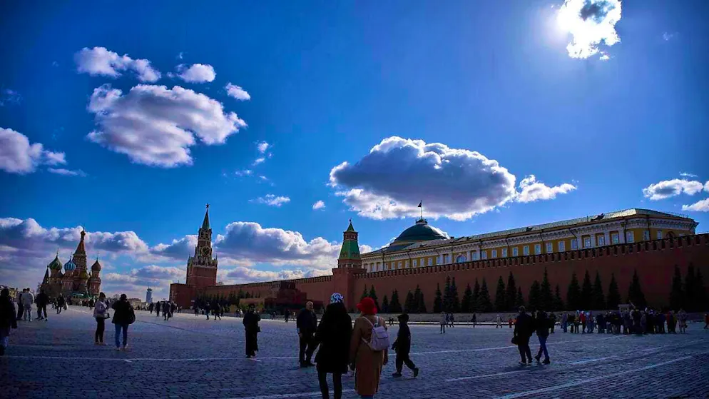 People walk across Red Square with the Kremlin in the background in Moscow. Photo: Alexander Zemlianichenko/AP/dpa
