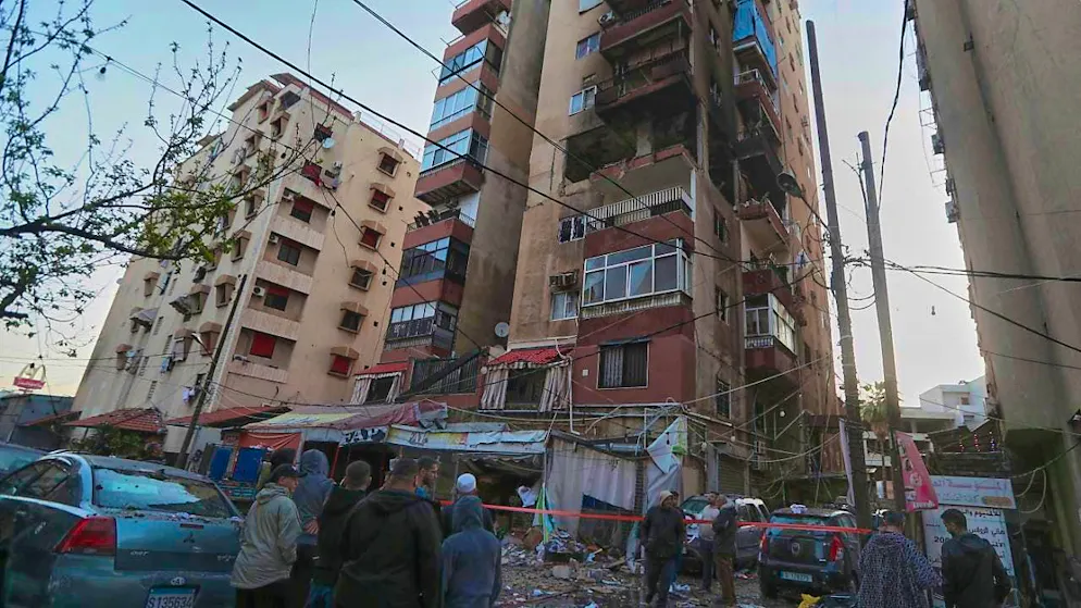 Residents gather near a destroyed apartment, which was allegedly hit by an Israeli airstrike, in the southern port city of Sidon. Photo: Mohammad Zaatari/AP/dpa