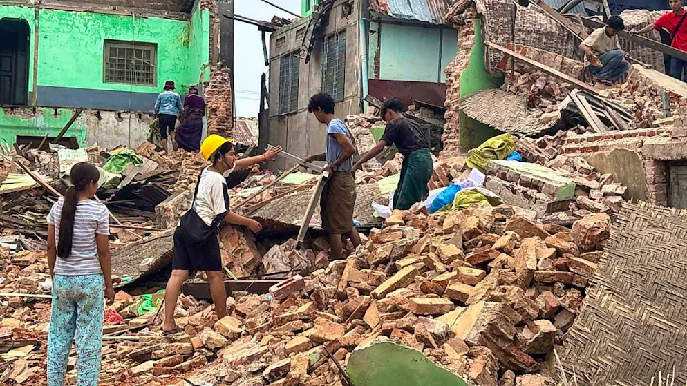 People clear rubble from damaged buildings after an earthquake on March 28. Photo: Uncredited/AP/dpa