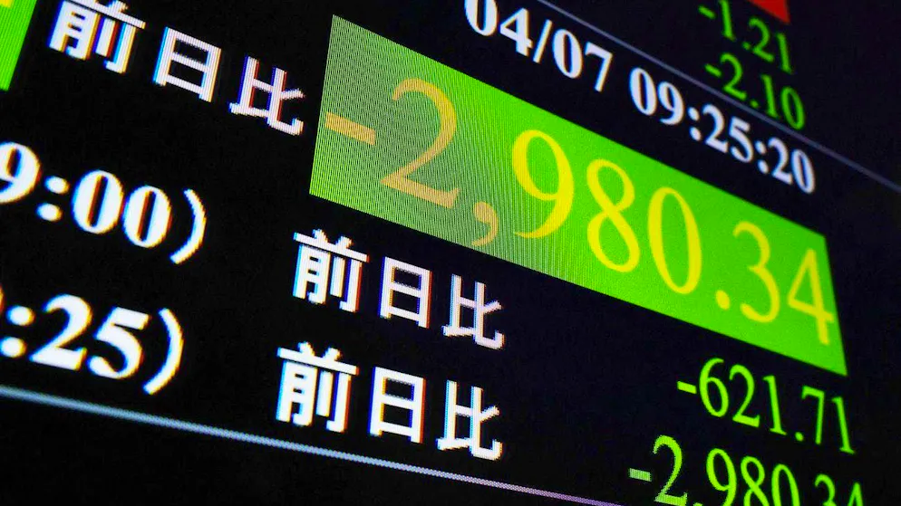 The crash of the Nikkei can be seen on a display in Tokyo on Monday morning. Unlike in the West, green figures on the Japanese stock exchange stand for price losses, red for gains.