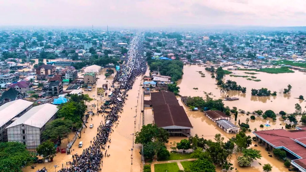dpatopbilder - People walk through the flooded streets of the capital of the Democratic Republic of the Congo after heavy rains. Photo: Samy Ntumba Shambuyi/AP/dpa