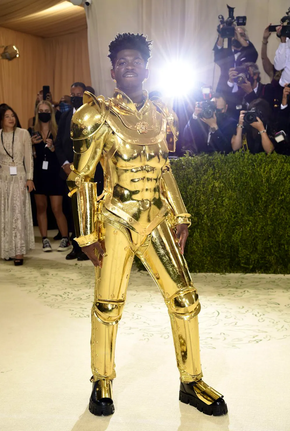 7 créations emblématiques de Donatella Versace pour ses 70 ans. Peu après avoir foulé le tapis rouge avec sa cape, Lil Nas l'a retirée pour dévoiler une armure dorée.