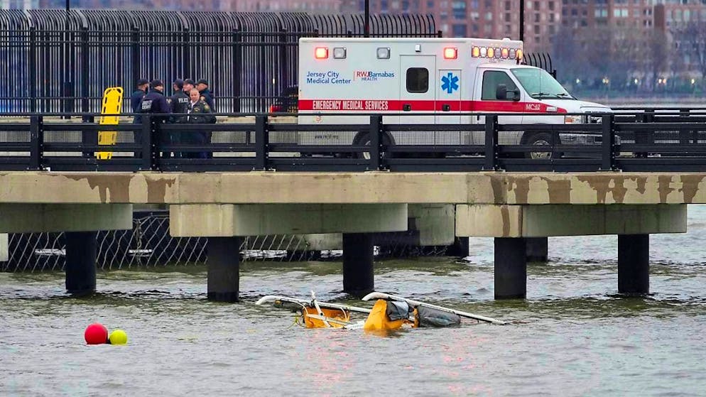 First responders stand at the site where a helicopter crashed into the Hudson River. Photo: Seth Wenig/AP/dpa