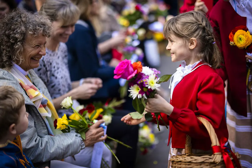 Sechseläuten 2024. Ein Mädchen verteilt Blumen an Zuschauer am traditionellen Umzug der Zünfte.