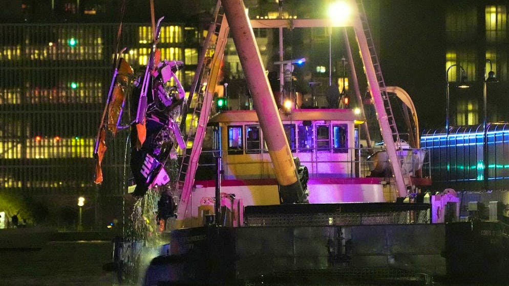 A crane ship pulls the helicopter wreckage out of the Hudson on Thursday evening.