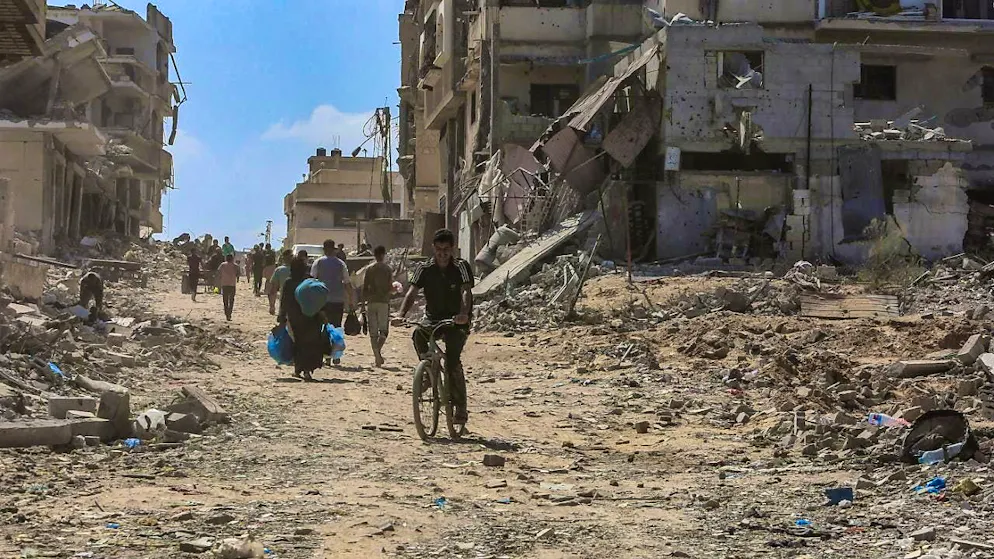 ARCHIVE - Palestinians walk in front of destroyed buildings. Photo: Abed Rahim Khatib/dpa