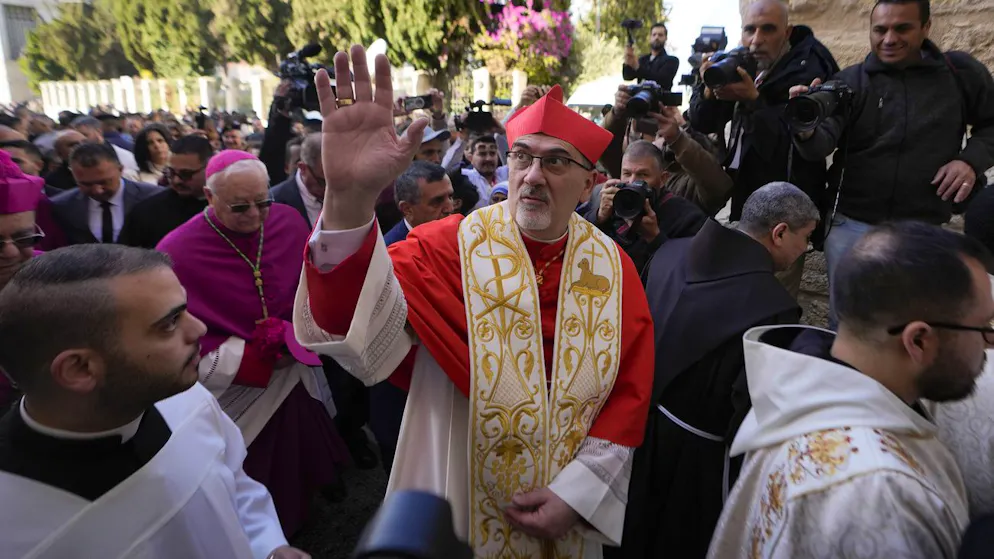 Il Patriarca latino Pierbattista Pizzaballa, il massimo esponente del clero cattolico in Terra Santa, al centro, saluta mentre arriva alla Chiesa della Natività, nella città cisgiordana di Betlemme, tradizionalmente ritenuta il luogo di nascita di Gesù, .