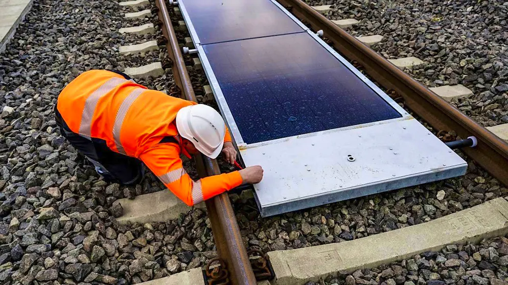 Railroad line opened with mobile solar modules - Gallery. A worker checks the installation of the solar modules between the tracks.