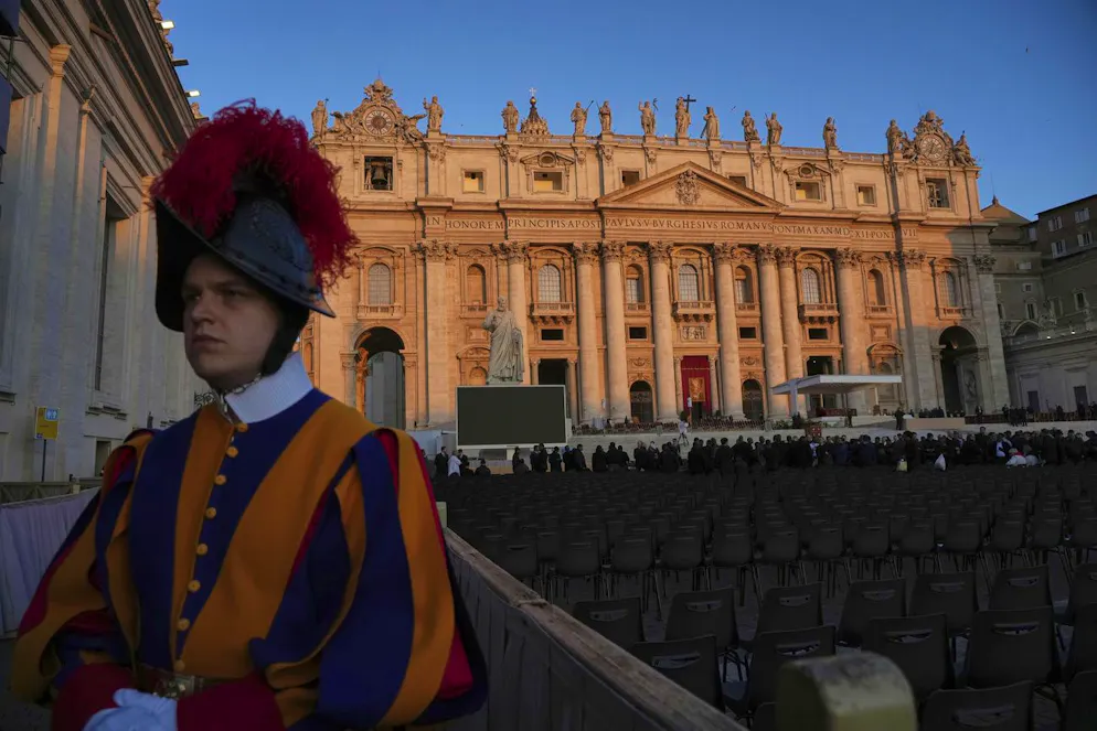 Un garde suisse pontifical se tient devant la basilique Saint-Pierre au lever du soleil, avant les funérailles du pape François sur la place Saint-Pierre au Vatican, le samedi 26 avril 2025.