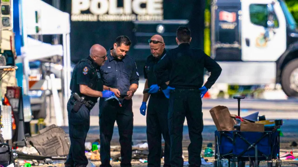 Members of the Vancouver police forensics team examine a victim's phone as they investigate a crime scene after a motorist drove into a crowd during a Filipino community festival, killing several people. Photo: Rich Lam/The Canadian Press/AP/dpa - ATTENTION: For editorial use only and only with full attribution to the above credit