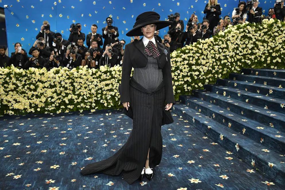 Rihanna – le défilé de tenues de grossesse a commencé!. C’est avec fracas qu’elle avait annoncé sa grossesse, dans une tenue extravagante lors du Met Gala, cet événement mode qui est sans doute le plus passionnant de l’année. Pour ce thème axé sur la mode masculine et l'histoire du dandysme noir, elle arborait une création signée Marc Jacobs: une jupe de tailleur à rayures noires et une veste en laine cropped, sous laquelle un bustier en maille soulignait parfaitement son baby bump.