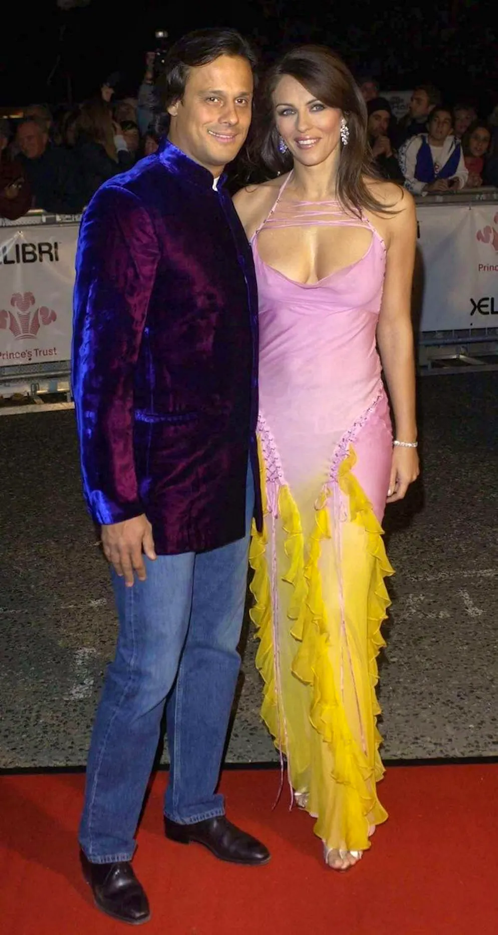 A 60 ans Liz Hurley ne change... rien!. Elizabeth Hurley et son compagnon Arun Nayar lors de l'événement «Fashion Rocks For The Prince's Trust» en octobre 2003. L'actrice arborait une slip dress à volants avec un dégradé de couleurs.