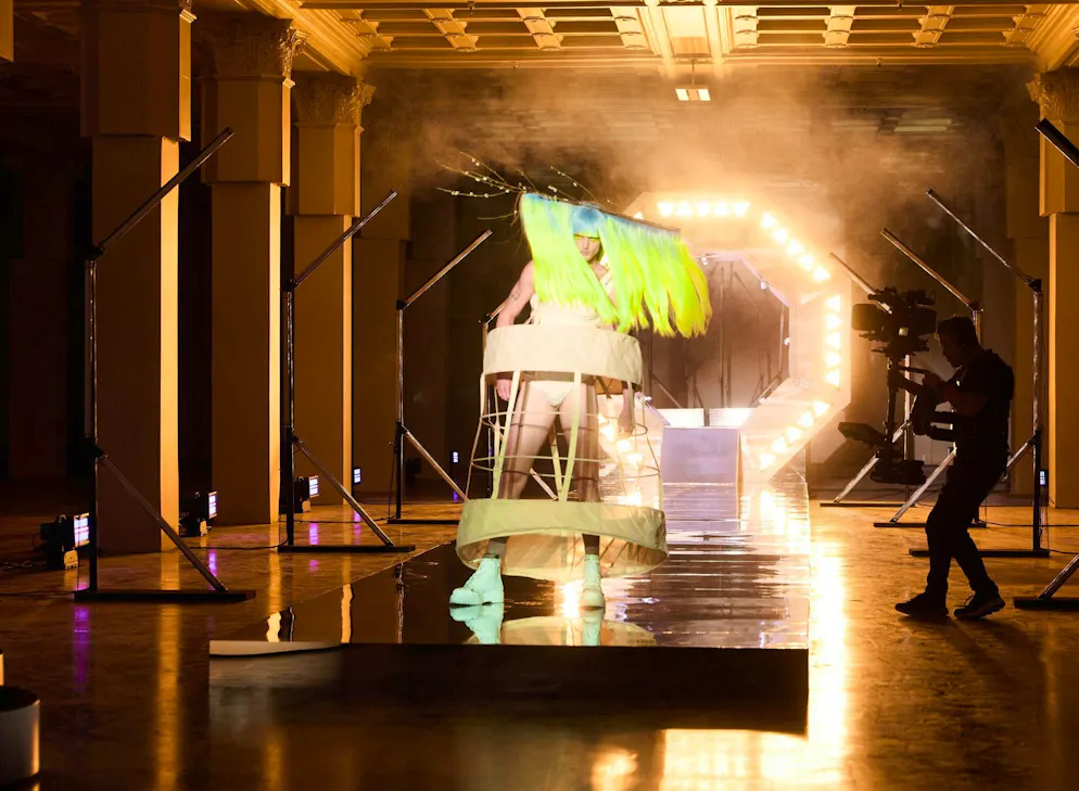 Yannik Zamboni dans l'épisode 22. Pour les candidat·e·s, l’épisode 22 s’annonce particulièrement éprouvant en raison de sa vision artistique. Les mannequins reçoivent de la colle et des fibres textiles soufflées sur le visage, portent des plumes en guise de faux cils – ainsi que d’énormes perruques sur la tête.
