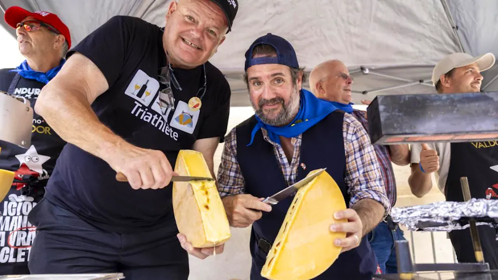 Raclette ou raclonette: la paix a été signée à Saint-Gingolph (VS) - Gallery. Eddy Baillifard (à gauche), ambassadeur du Raclette Valais AOP, et l'humoriste français Jason Chicandier (à droite) raclent des fromages pour la paix et l'amitié des raclettes entre les deux pays.