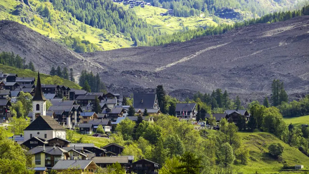 Au premier plan, le village de Kippel où les élèves de secondaire sont scolarisés. En arrière-plan, l'avalanche qui a enseveli le village de Blatten.