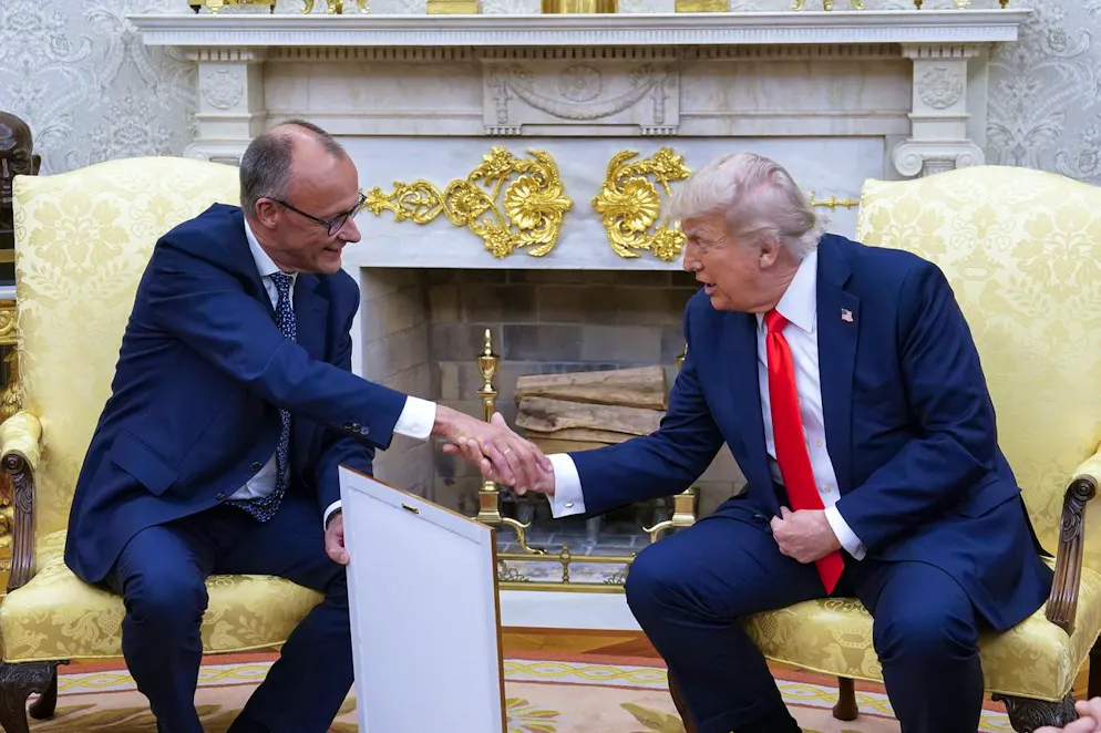 epa12158328 German Chancellor Friedrich Merz (L) presents US President Donald J Trump with what he said is the birth certificate of Trump's grandfather, 'Born in 1869,' as they meet at the Oval Office of the White House in Washington, DC, USA, 05 June 2025. EPA/CHRIS KLEPONIS / POOL