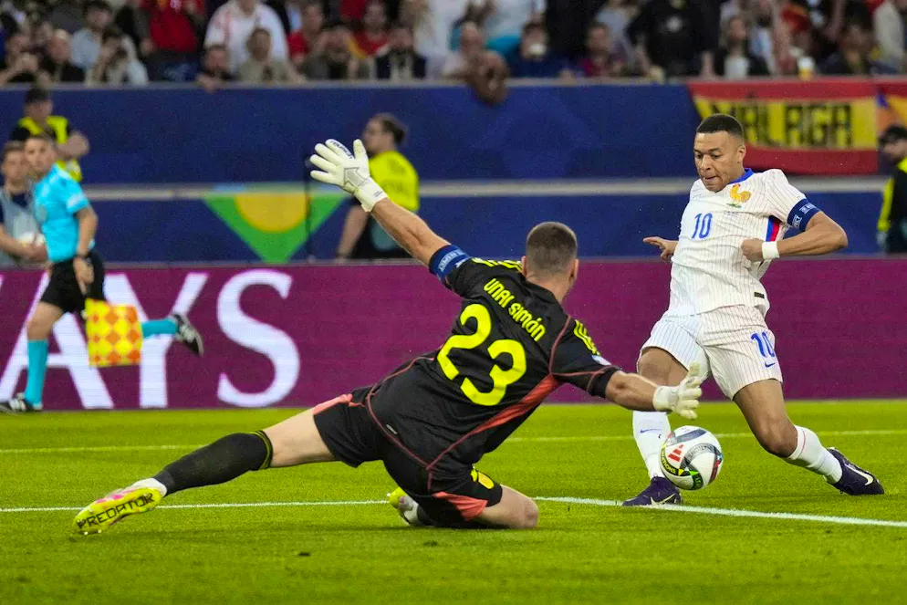Spain goalkeeper Unai Simón stops France's Kylian Mbappé.