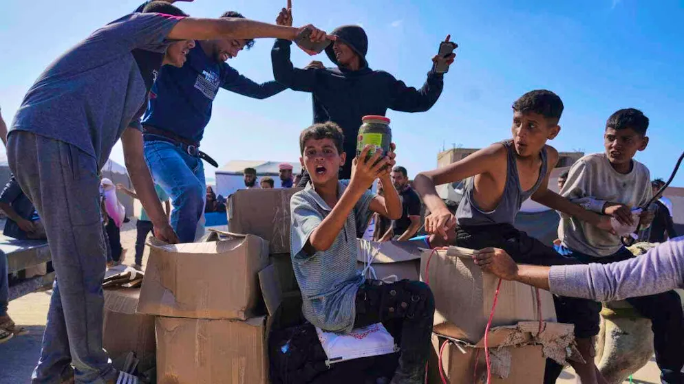 dpatopbilder - Palestinians carry boxes of food and humanitarian aid packages delivered by the Gaza Humanitarian Foundation in Rafah in the southern Gaza Strip. Photo: Abdel Kareem Hana/AP/dpa