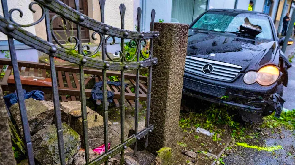 dpatopbilder - A damaged car stands on a sidewalk. A man has driven a car into a group of people in Passau. The police suspect a relationship. Among the five injured are the driver's 38-year-old wife and a five-year-old daughter. Photo: Armin Weigel/dpa