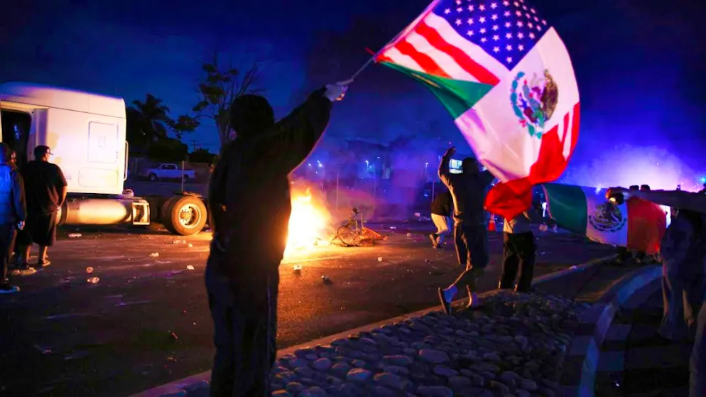 dpatopbilder - A protester waves an American and a Mexican flag during a demonstration in Compton, California. Photo: Ethan Swope/AP/dpa